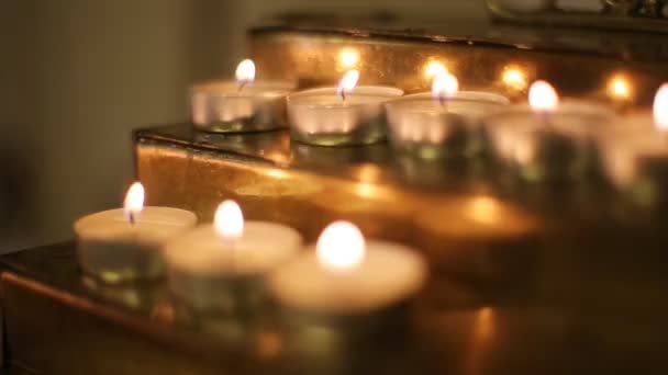Muchas llamas de velas brillando en la oscuridad — Vídeos de Stock