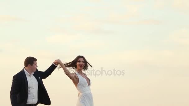 Glückliche Braut tanzt neben ihrem Bräutigam auf dem Weizenfeld — Stockvideo
