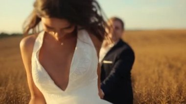 Gelin ve damat elele ve buğday alanı atlama