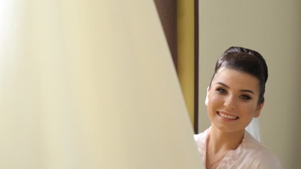 Счастливая невеста улыбается рядом с платьем — стоковое видео