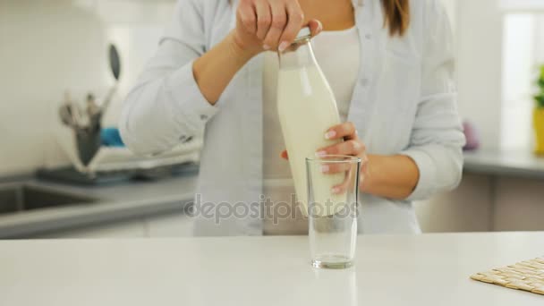 Frau schüttet sich Milch aus Flasche ins Glas. — Stockvideo