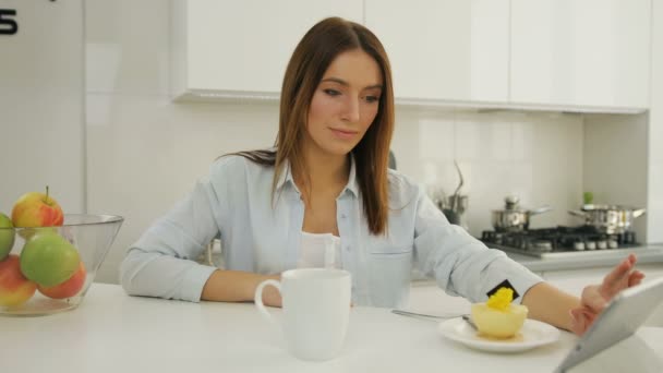 Atractiva joven mujer mirando su tableta y desplazándose . — Vídeo de stock