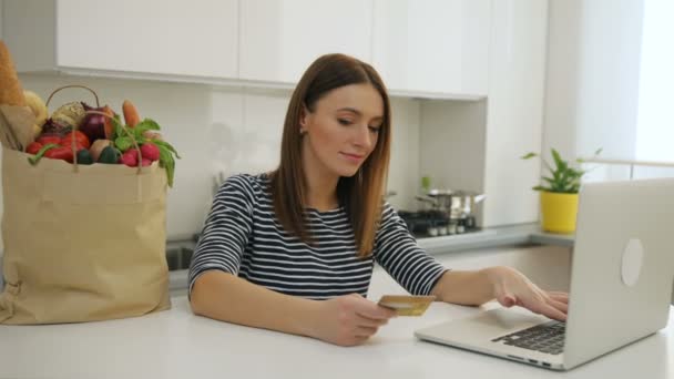 Frau kauft mit Laptop ein und bezahlt online mit Kreditkarte — Stockvideo