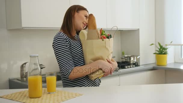 Jonge vrouw kwam terug thuis na het winkelen, praten door slimme telefoon — Stockvideo