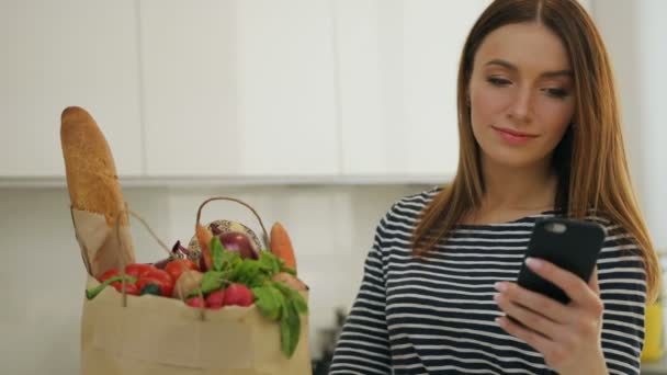 Jonge vrouw texting op haar mobiel na het winkelen. — Stockvideo