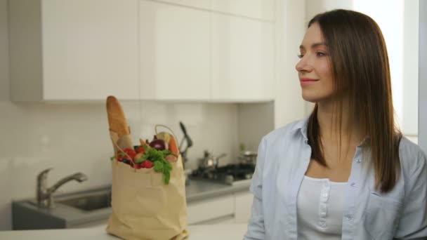 Крупним планом портрет красивої жінки, що посміхається на білій кухні — стокове відео