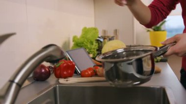 Kadın mutfakta sebze salata hazırlamak için gidiyor.