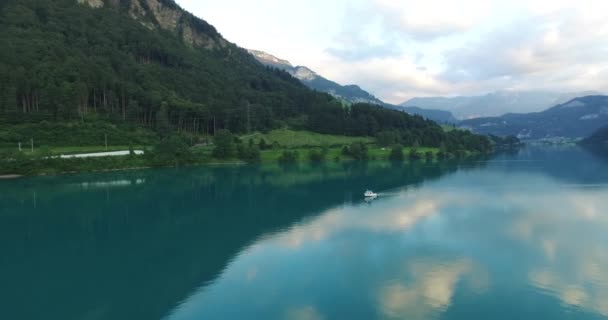 Letecký pohled na lodi plovoucí na řece mezi horami švýcarských Alp. — Stock video