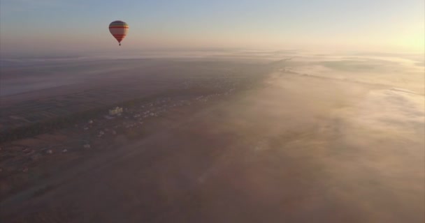 Flygfoto över varm luftballong flyter i ren blå himlen på soluppgången — Stockvideo