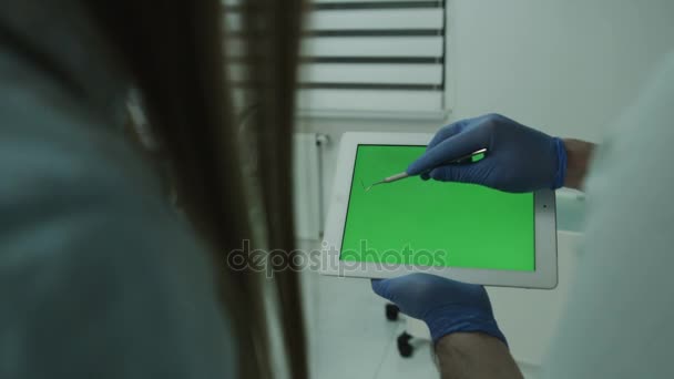 Dentista presso il tablet pc spiegando procedura al paziente in clinica dentale — Video Stock