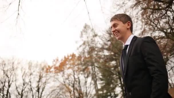 Sorrindo noivo andando para bela noiva e beijando-a no parque dourado Autm — Vídeo de Stock