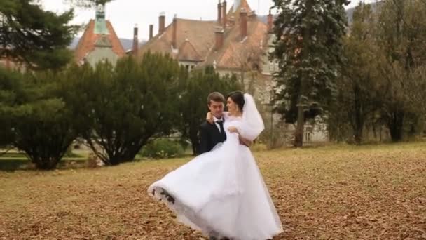 Sposo sposa oscillante sulle sue mani vicino al vecchio castello antico — Video Stock