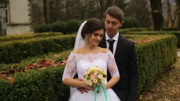 Szép mosolygó menyasszony kezében míg átölelve őt vőlegény esküvői csokor. — Stock videók