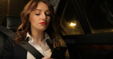 Araba ve akıllı telefonda konuşurken arka koltuğunda iş kadını rides