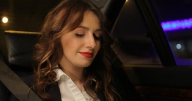 İş kadını araba ve telefonda konuşurken rides. Arka plan şehir ışıkları