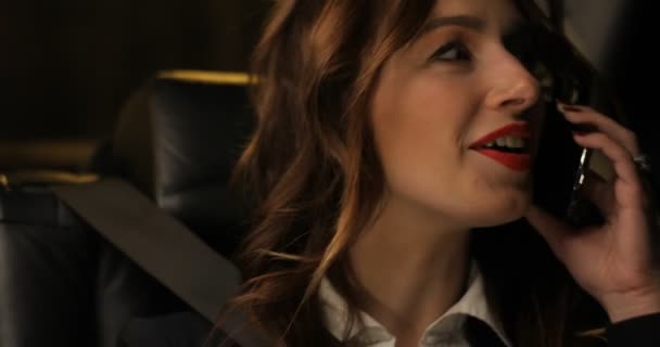 Mujer gerente contestando y hablando de teléfono móvil en el asiento trasero del coche en movimiento — Vídeos de Stock