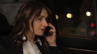 Kadın Yöneticisi mobil konuşurken telefon arka tarafta hareketli araba koltuğunda geceleri