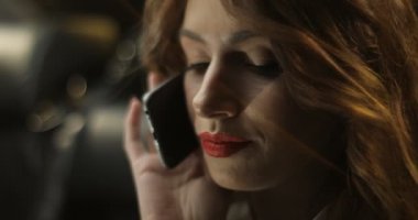 Kullanarak, geceleri araba penceresi aracılığıyla cep telefonu konuşurken büyüleyici kadın