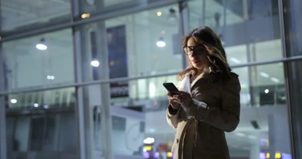 Hermosa mujer está respondiendo a una llamada telefónica, al aire libre en la ciudad por la noche . — Vídeos de Stock