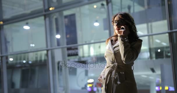 Hermosa mujer está haciendo una llamada telefónica, al aire libre en la ciudad por la noche . — Vídeos de Stock