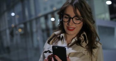 Sevimli kadın bir telefon görüşmesi, açık havada gece şehirde yaşıyor.