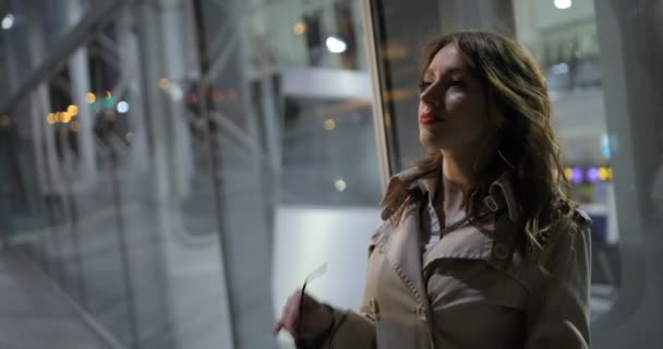 Charming woman is wearing glasses on, outdoors in the city at night. — Stock Video