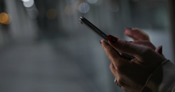 Primo piano di giovani mani donna digitando sms e scorrimento immagini sul telefono — Video Stock