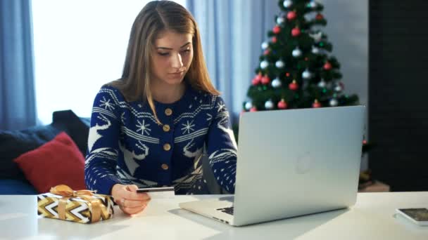 Νεαρό κορίτσι κάνει on-line χριστουγεννιάτικα ψώνια με το laptop της και την πιστωτική της κάρτα — Αρχείο Βίντεο