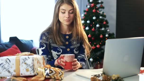 Chica bebiendo té caliente en el trabajo. Fiesta de Navidad y feliz año nuevo — Vídeos de Stock