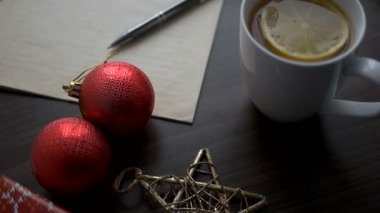 Oyuncaklar, yıldız ve not defteri kahverengi ahşap masa üzerinde Noel çay. Noel dekorasyonu. Üstten Görünüm.