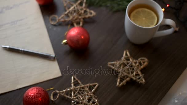 Mesa de madera marrón con decoración navideña, estrellas, juguetes, abeto, té, guirnalda. Vista superior . — Vídeo de stock