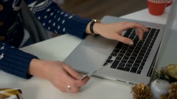 Jonge vrouw handen kopiëren de nummers van kaarten naar de laptop, betalen voor sommige diensten. — Stockvideo