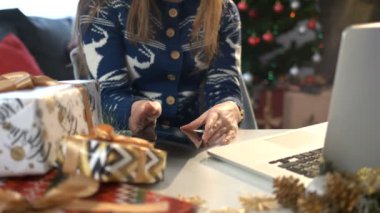 Kadın el tablet Noel dekorasyonu ve Noel ağacı arka plan üstünde laptop tablo kullanma.