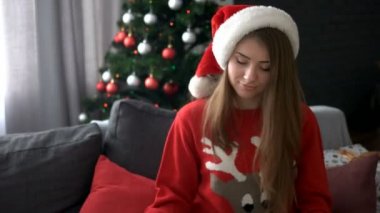 Bir hediye Divan pencere ile Noel ağacı arka planda tutan çekici mutlu kadın.