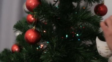 Eller genç kadın Noel Baba şapkalı bokeh arka plan üzerinde Noel ağacı süsleme.