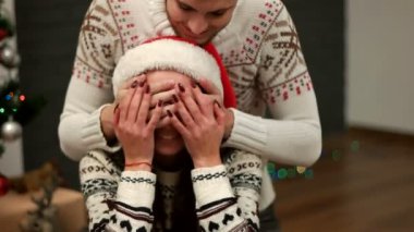 Onun kadın gözünde kapanış ve Noel hediye vermek bir genç adam. Adamdan hediye açılış mutlu güzel kadın.