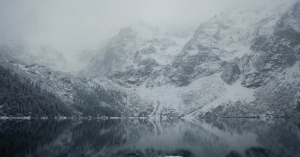 Zugefrorener See in winterlicher Berglandschaft mit Schneefall. bei winterlichem Wetter. — Stockvideo