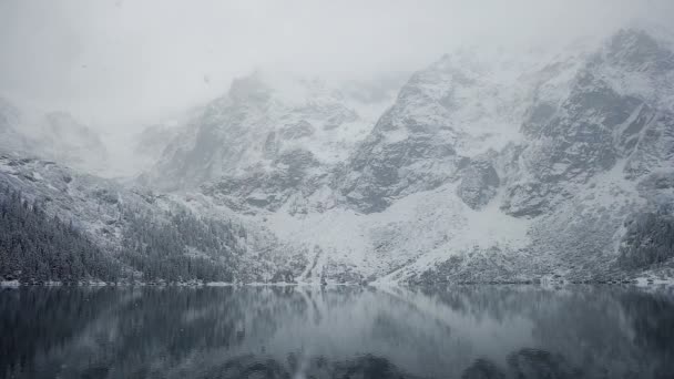 Zugefrorener See in winterlicher Berglandschaft mit Schneefall. bei winterlichem Wetter. — Stockvideo