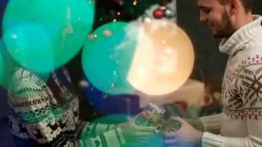 Güzel genç çift Noel alışverişi bokeh ışık christmastree zemin üzerine sunar.