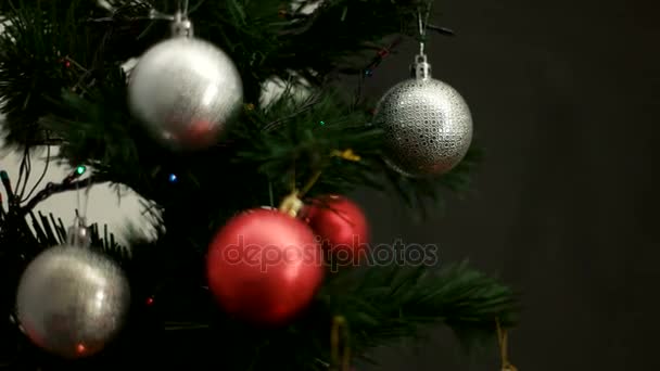 Árbol de Navidad con juguetes rojos y plateados sobre fondo bokeh claro. De cerca. . — Vídeo de stock