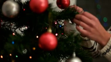 Bir Noel ağacı kırmızı ve gümüş oyuncak oturma odasında dekorasyon eller kadın. Yakın çekim.