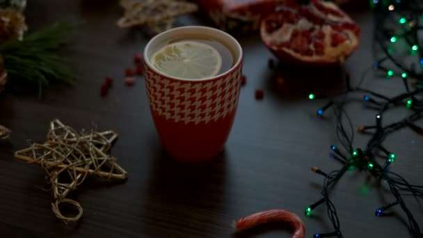 Acogedora decoración navideña en mesa de madera negra. Luces de Navidad, té. Vista superior, Dolly tiro — Vídeos de Stock