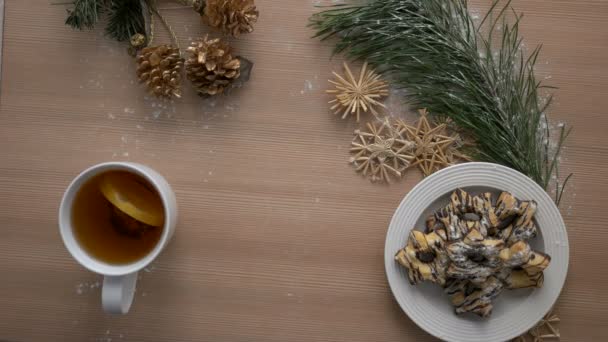 Acogedora vista superior de Navidad. Decoración navideña, galletas, té sobre mesa de madera clara. Disparo desde arriba. — Vídeos de Stock