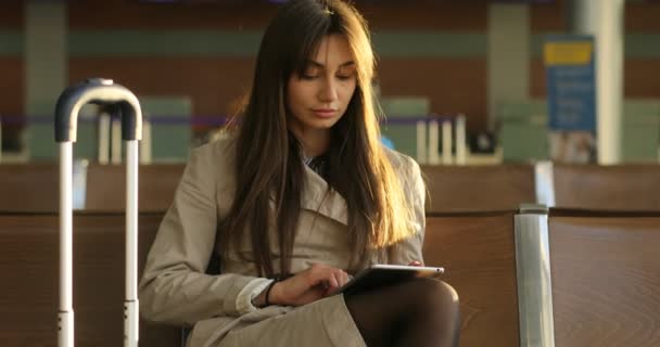 Dość młoda kobieta pasażera przeglądania tablet z plecaka i przewozu w bagażu na lotnisku międzynarodowym, — Wideo stockowe