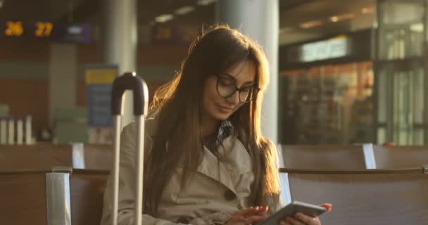 Mujer de abrigo beige habla por teléfono en el aeropuerto — Vídeo de stock