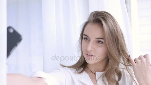 Юная брюнетка фотографирует себя на мобильный телефон, селфи — стоковое видео