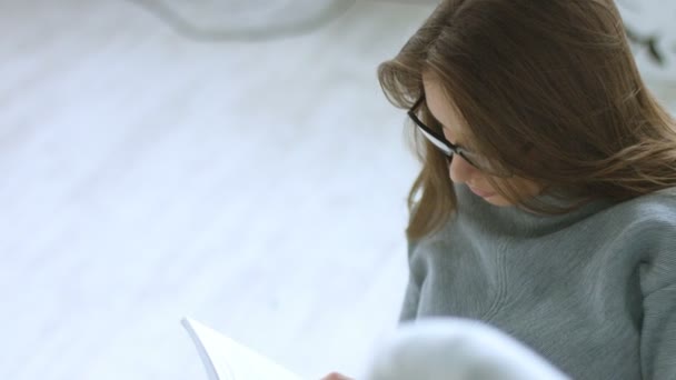 Молода красива дівчина читає книгу — стокове відео