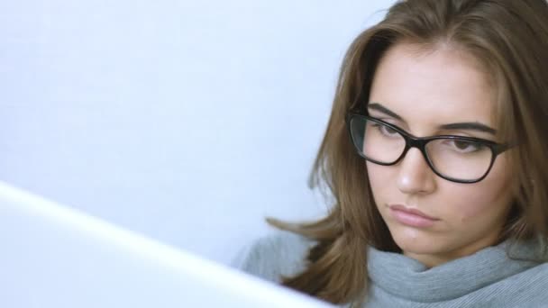 Atractiva mujer joven en gafas usando portátil — Vídeos de Stock