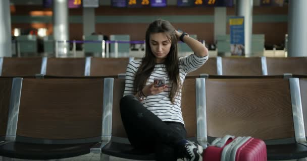 Chica bastante joven usando el teléfono inteligente para leer noticias de Internet — Vídeos de Stock