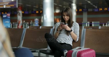 İnternet haberleri okumak için smartphone kullanırken pretty genç kız gülümseme